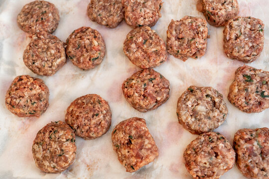 Cooking Ground Meat Patties on a Baking Sheet in the Kitchen