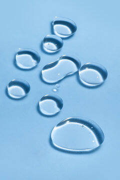 Droplets of Face Serum on a Blue Background