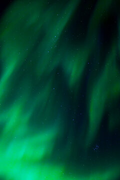 Green aurora lights in a dark night sky