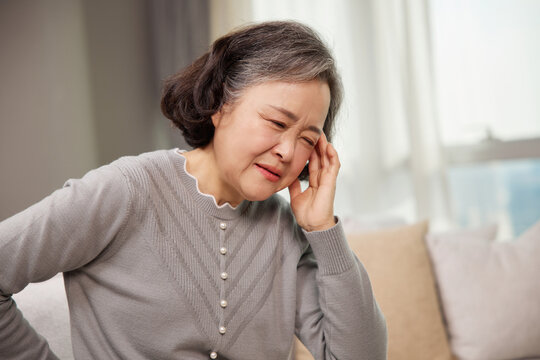 Elderly woman feeling dizzy and unwell at home