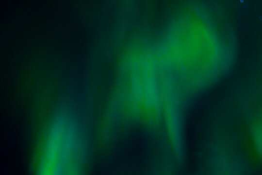 Abstract green light waves with glowing streaks on a dark background