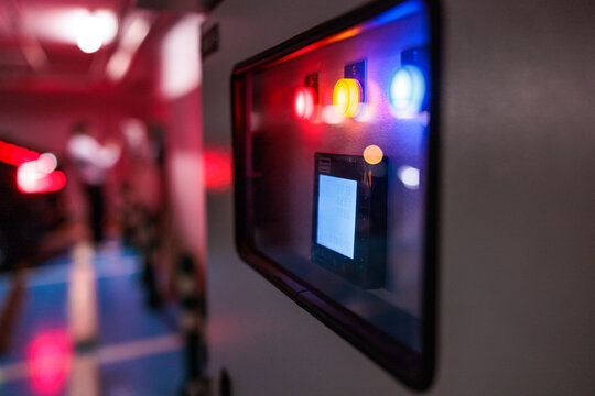 Control panel with vibrant lights and digital screen in darkness.