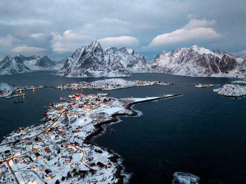 Snowy coastal village beside a mountain fjord