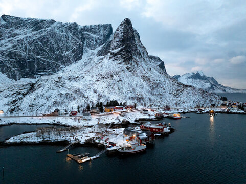 Snowy mountain village and harbor at dusk