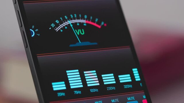 The smartphone screen displays the VU (Volume Unit) meter or level meter, as well as wireless controls and settings. Sound mixer, recording studio, adjustment of frequencies, volume.