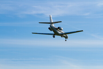Private business jet approaching for landing against a clear blue sky   Prywatny odrzutowiec biznesowy zbliżający się do lądowania na tle czystego, błękitnego nieba © Adrian White