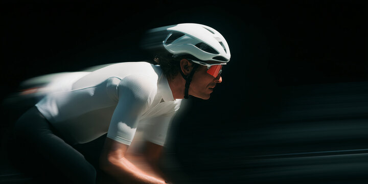 Professional cyclist in motion, wearing a white helmet and sunglasses, focused on the race