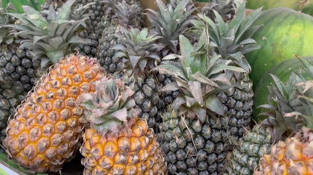 Fresh raw pineapples heap at local market close up