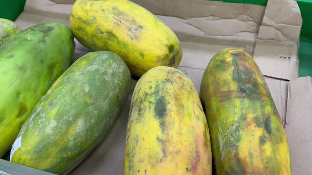 Fresh raw papaya fruits heap at local market close up