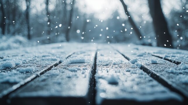 Snow falling on a wooden park bench, shallow depth of field, winter scene.