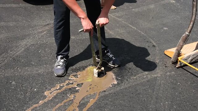 Extraction of an asphalt core sample after fresh paving of the road surface to check the quality of the new asphalt