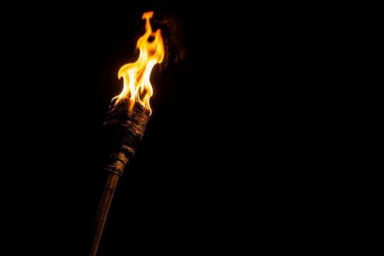 A single burning torch creating a focal point of light in darkness.