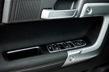 Obraz premium close-up of sleek modern car interior door panel with leather and plastic accents in a vehicle setting, showcasing a clean and contemporary design for automotive accessories.