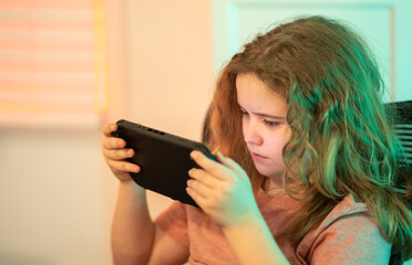 Kid play video game with joystick. Gamer concentration on screen. Child with gaming console. Kid playing online computer games. Gamer focused on the screen. © Volodymyr
