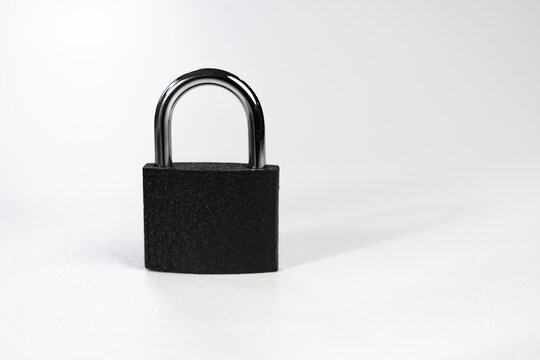 Closed black padlock with chrome shackle isolated on light background