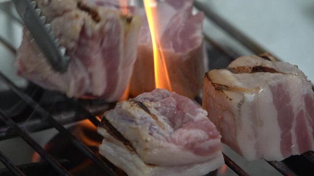 Pork belly charcoal BBQ grilled meat pork flame fire smoke k food traditional meat cooking recipe restaurant food ingredient 통돼지삼겹살 구이 삼겹살 돼지고기 숯불구이 한식 케이푸드 석쇠 불 고기 숯불 연기 불꽃 식재료 요리 음식 돼지구이 바비큐 직화구이