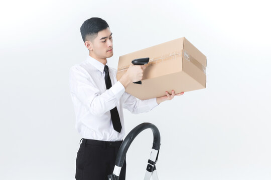 Warehouse worker scanning cardboard box with barcode reader on white background
