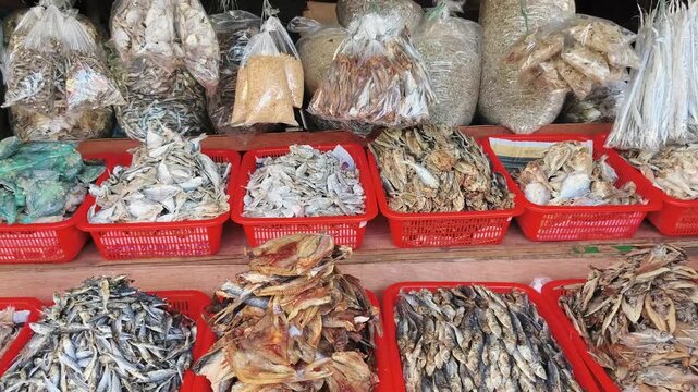 Rows of red trays hold dried fish and seafood at market stall