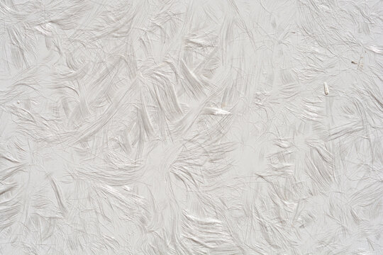 A detailed macro shot showing the fine glossy fiber strands embedded inside a white fiberglass reinforced plastic panel surface.