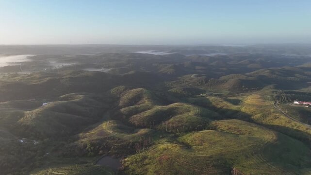 A beautiful push in aerial drone shot reveals a breathtaking misty sunrise over the rugged landscape of Aljezur, Portugal close to Chabouco. Part of the iconic Rota Vicentina and Fisherman's Trail.