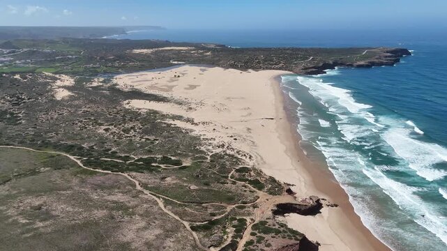 Aerial push in drone shot revealing the stunning rugged coastline and sandy beaches of the Fisherman's Trail, Rota Vicentina, near Carrapateira, Portugal. Capturing nature's beauty.