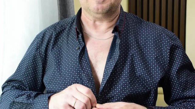 Close-up of a man adjusting his shirt collar