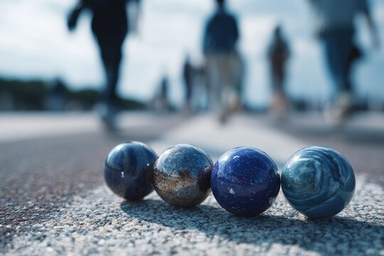 A close-up of four polished stone spheres in focus, blurred figures in the background