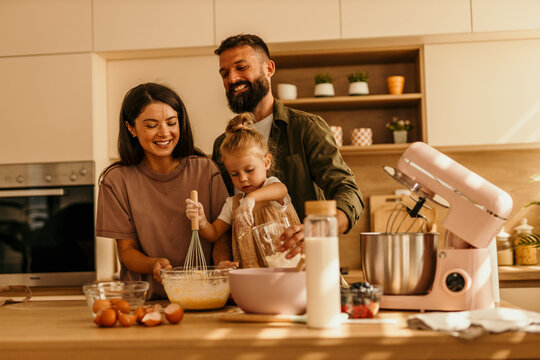 Family baking together in kitchen, preparing dessert