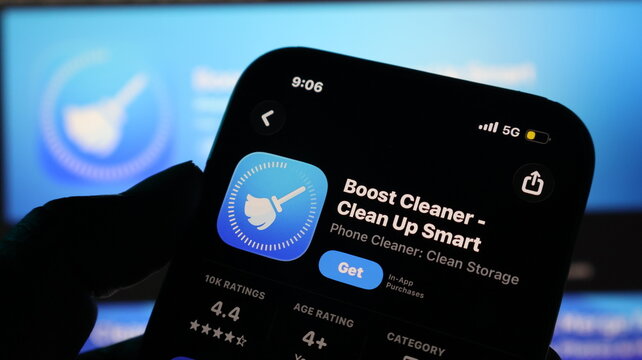 Hand holding smartphone with app store screen