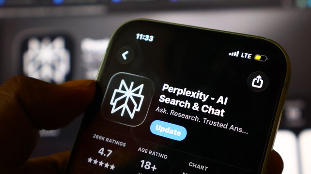 Hand holding smartphone with app store screen