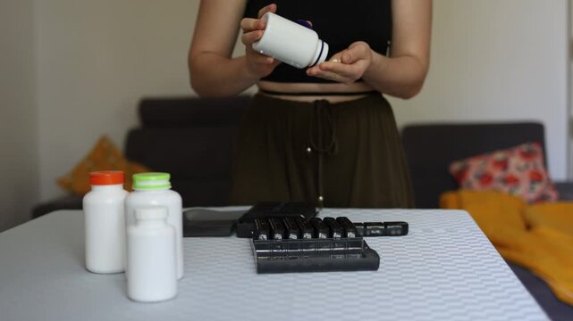 Everyday routine shaped by pharmaceutical culture as person opens supplement bottle and prepares pills highlighting influence of industry normalization of constant intake and dependency on products