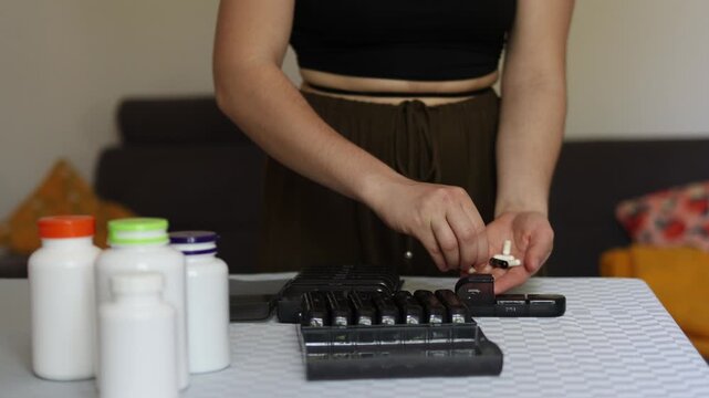 Modern lifestyle shows growing dependence on supplements as young person organizes daily pills in container reflecting global health anxiety routine control and fear of forgetting medication