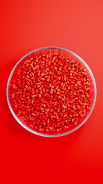 Rotating glass bowl filled with black polypropylene plastic granules and masterbatch resin pellets on black background, 3D render seamless Vertical video.