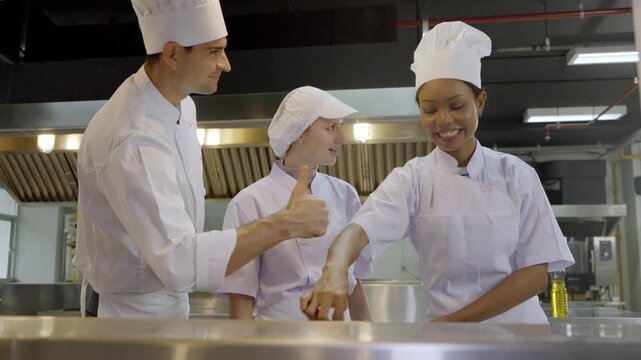 Chefs prepare food in a kitchen at a culinary school during an active cooking class