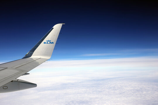 Dublin, Ireland - May 26th 2022: KLM - royal Dutch airlines plane wing in a blue sky with some clouds. Closeup color image taken from inside the passenger plane.