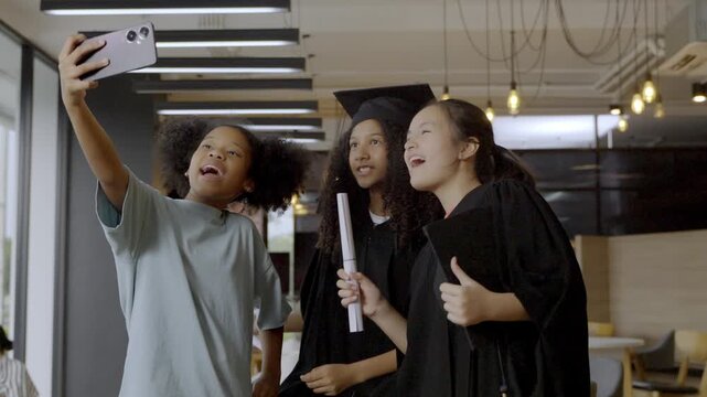 Graduation day celebration with friends taking selfies inside a cafe