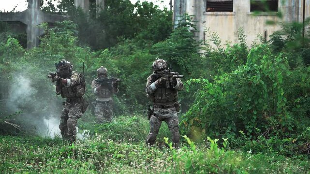 Soldiers engage in training drill in overgrown area near abandoned building