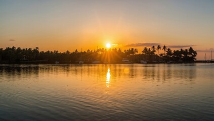 Naklejka premium Sunset Over the Beach With Mountains and Palm Trees in the Background Near a Calm Water Body