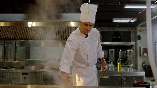 Chef prepares food in kitchen during dinner rush hour with busy atmosphere and smoke rising from the stove