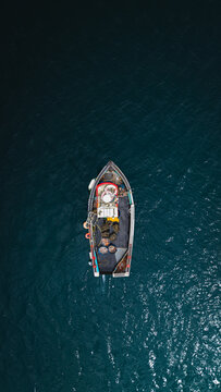 Top down aerial view of a small Cornish fishing boat on open water