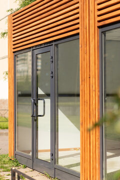 Modern wooden louver facade with glass door outdoors, architectural detail, contemporary exterior design, natural material, building entrance.