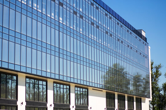 Reflective glass office building exterior in a modern city, corporate architecture, business real estate, contemporary urban facade.