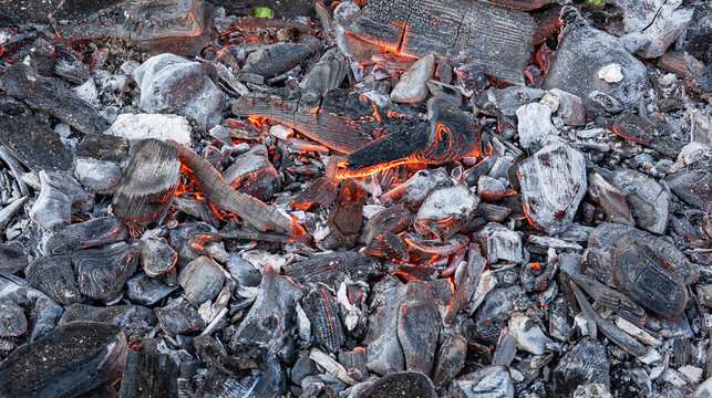 Glowing charcoal briquettes with burning embers background