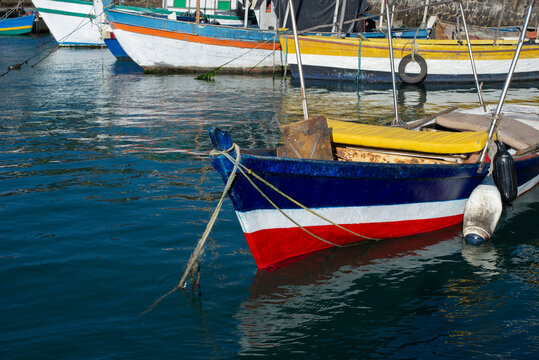 Colorful wooden boats moored at the stone quay