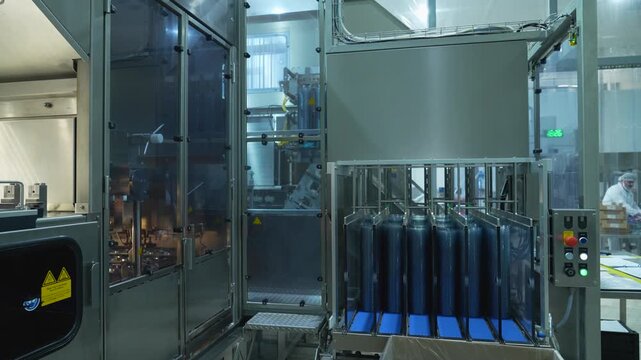 Automated dairy packaging line with stacks of blue plastic lids in a modern sterile food processing facility