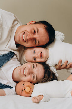 A happy family with two children poses during a home photo session.