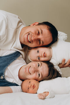 A happy family with two children poses during a home photo session.