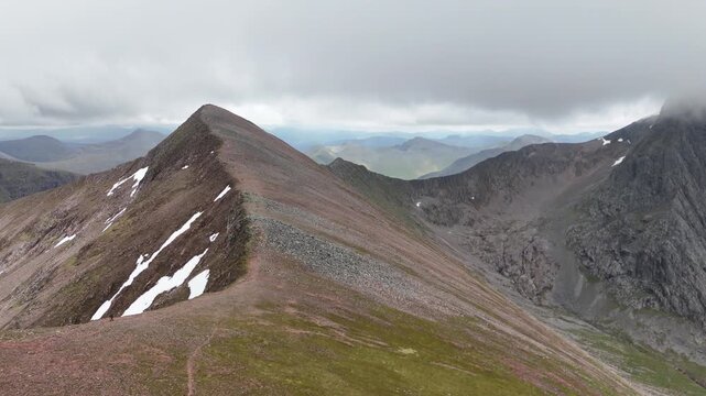 Aerial drone push forward of a hiker walking on the CMD route to Ben Nevis in Scotland.