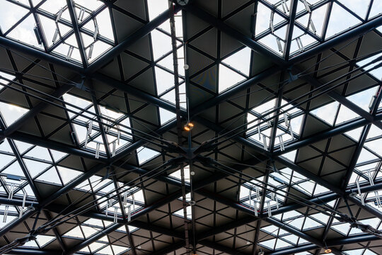 Low angle view of modern geometric steel glass roof framework construction abstract architectural background