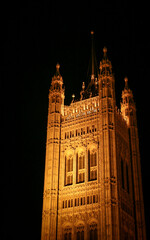 Obraz premium Central Tower Of Parliament. Low angle view of historic palace architecture illuminated against a dark night sky.
